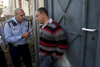Camal Agarbiya, the head of the Ajami neighborhood local council in Jaffa, attempts to prevent police officers from evicting an Arab family from their home in the neighborhood, January 2008<br>Oren Ziv/activestills.org<br>