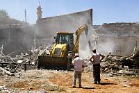 A bulldozer, commissioned by the Israel Land Administration (ILA) destroys the foundations of the Adassi family's home in the Ajami neighborhood of Jaffa, August 2007. The foundations were laid anew by social activists after the ILA had destroyed the house two weeks earlier. <br>Yotam Ronen/activestills.org<br>